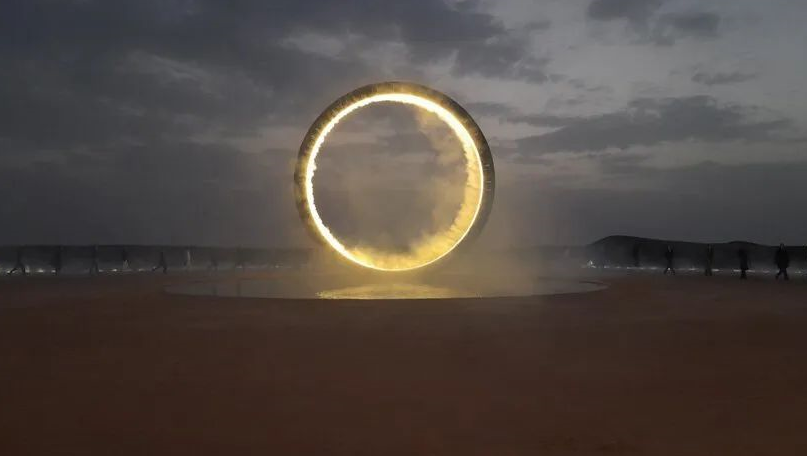 环形发光的「满月」冉冉升起，将秀场搬进沙漠海市蜃楼